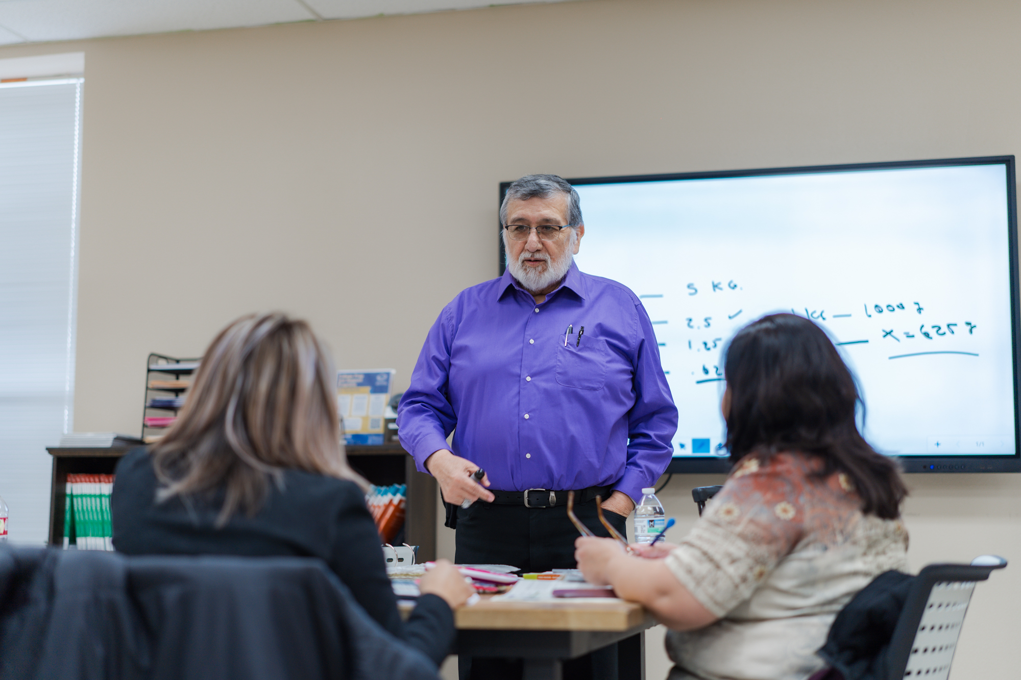 Teacher leading a math lesson at the whiteboard in a Restore Education classroom